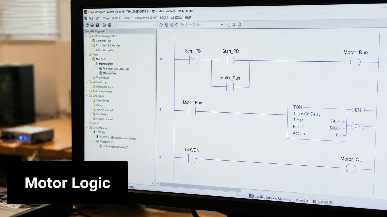 A computer monitor displaying ladder logic code for a motor control program in Rockwell Automation Logix Designer software.